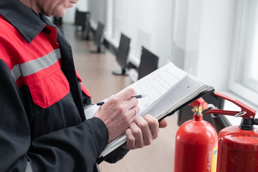 Ein Sachverständiger überprüft den Brandschutz und benutzt dabei eine Checkliste VDE 0833